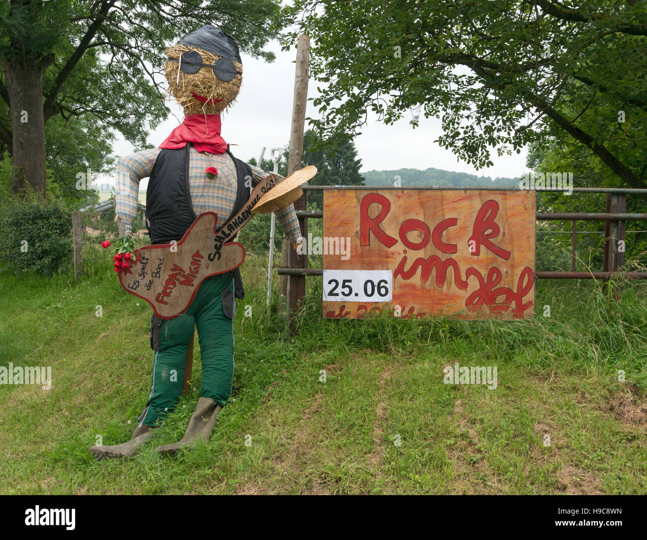 Amusing diorama advertising a rock music concert with a straw stuffed mannequin holding a guitar, Germany, Europe Stock Photo