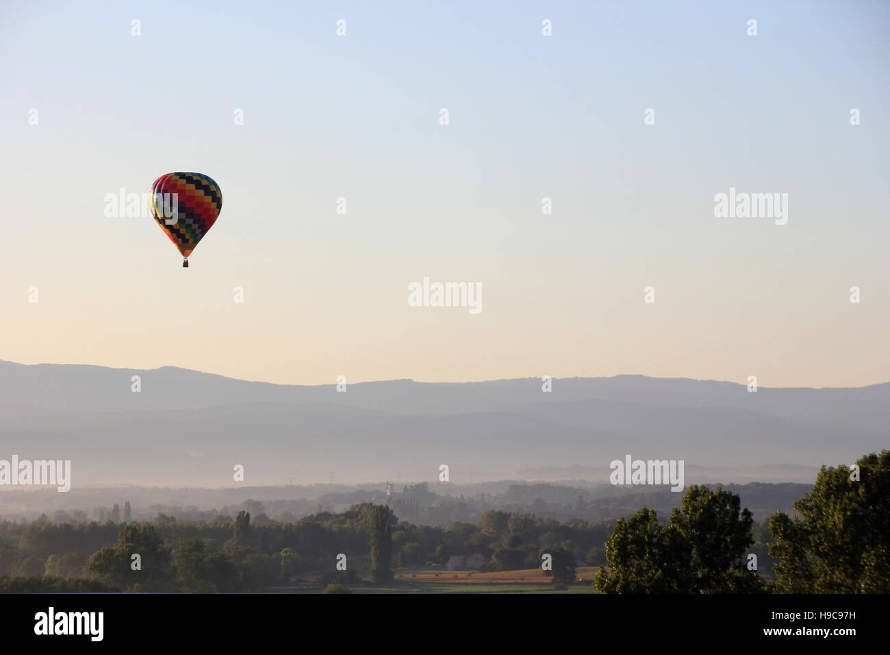 Hot air balloon in the morning mist over the fields of france Stock Photo