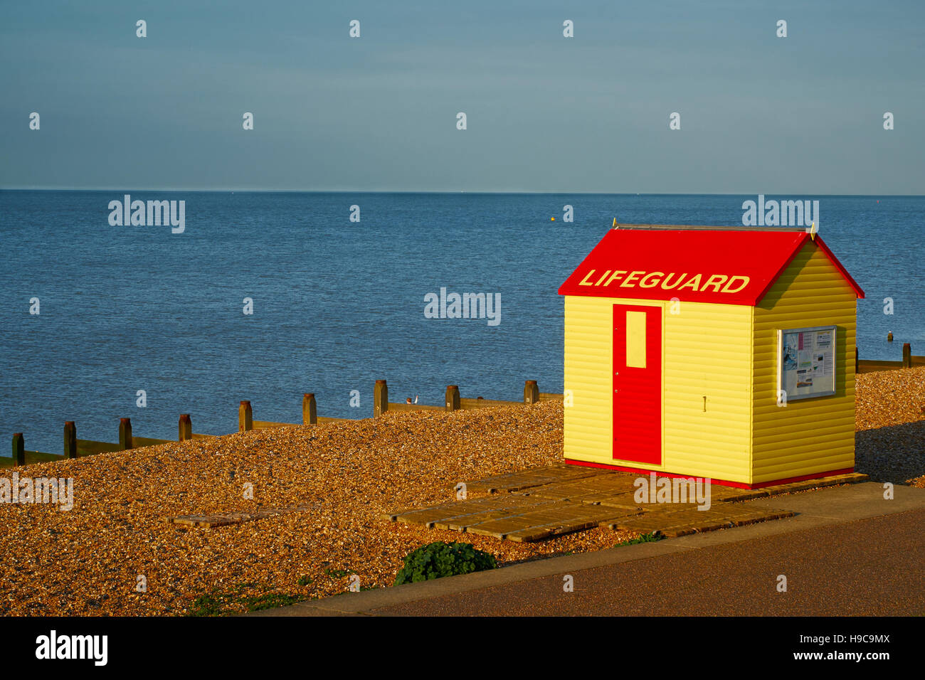A yellow and red lifeguard hut on the beach at Whitstable, Kent Stock Photo