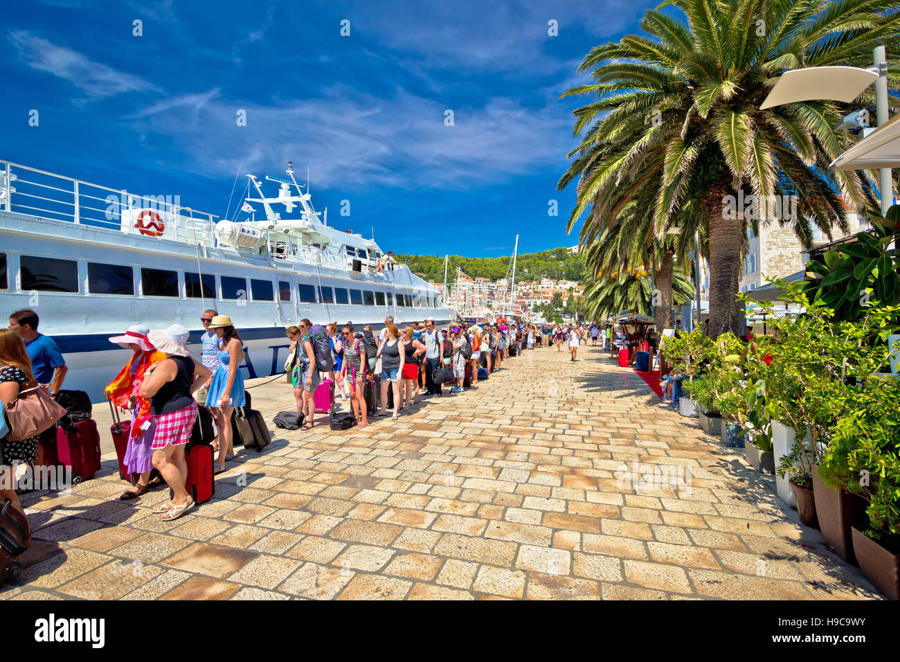 Hvar, Croatia, August 25, 2014: Hvar island harbor tourist queue. People waiting in line to board speedboat. Hvar is famous tourist destination, overc Stock Photo
