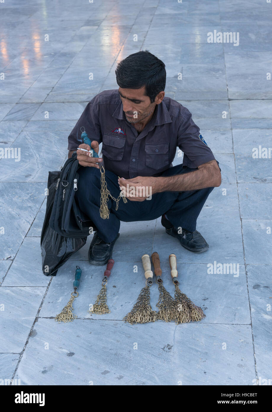 Man selling iron chains for children in fatima al-masumeh shrine during muharram, Central county, Qom, Iran Stock Photo