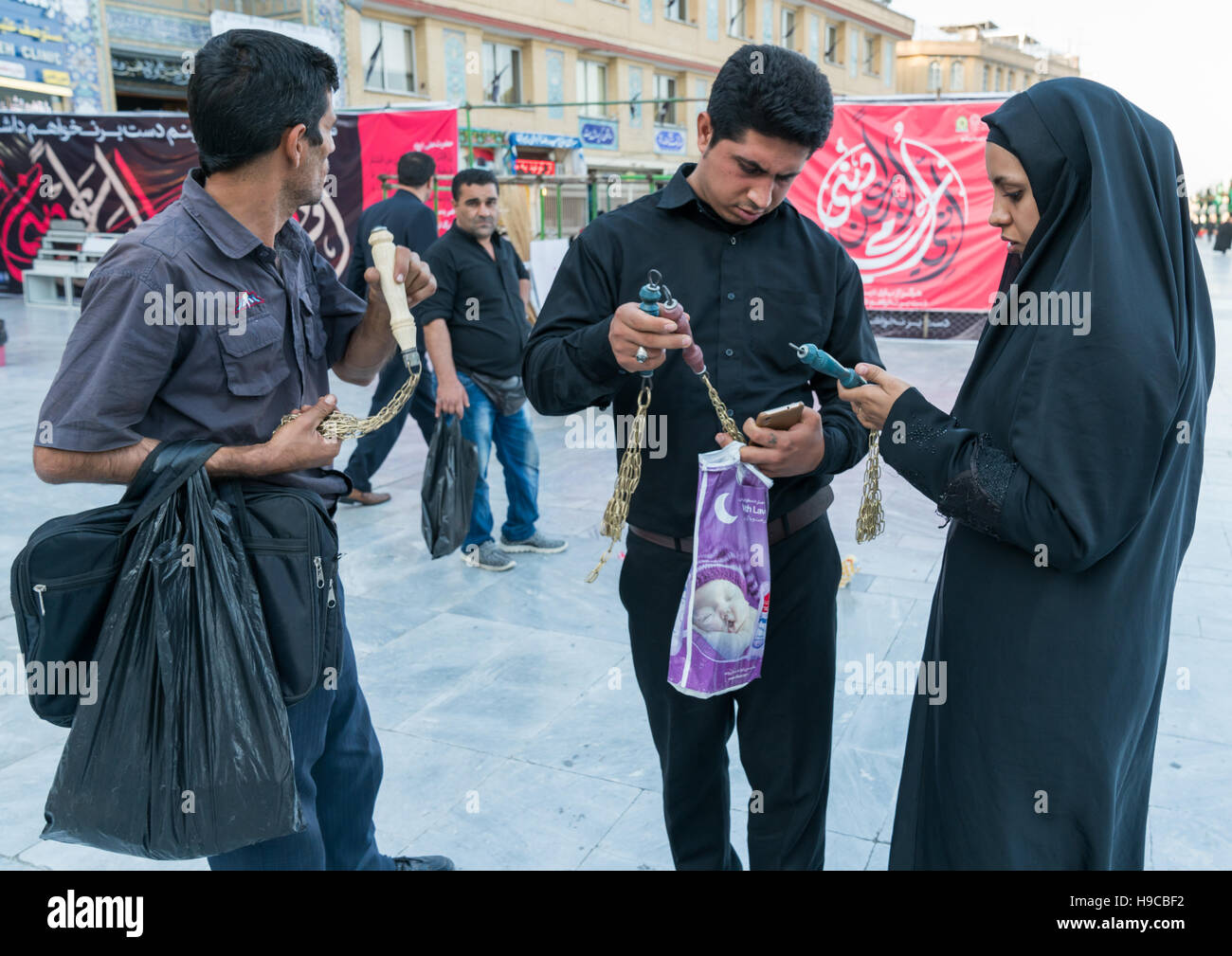 Shiite couple buying iron chains for children in fatima al-masumeh shrine during muharram, Central county, Qom, Iran Stock Photo