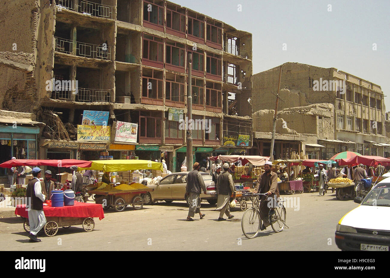 29th May 2004 A typical street scene in Kabul, Afghanistan: a street market next to bomb-damaged buildings. Stock Photo