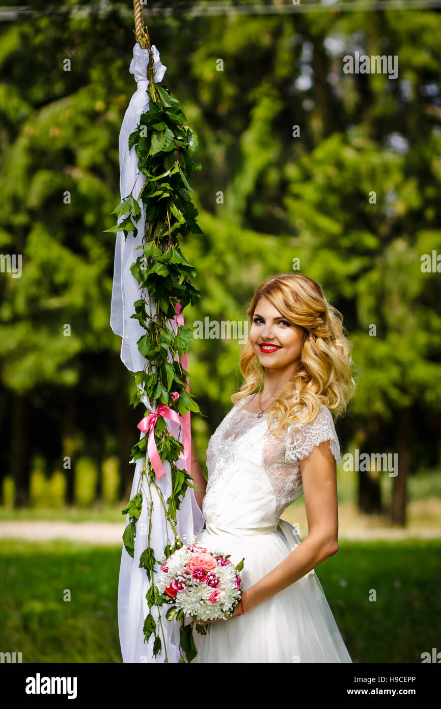 Beautiful blond bride in a white wedding dress standing in front of the ...