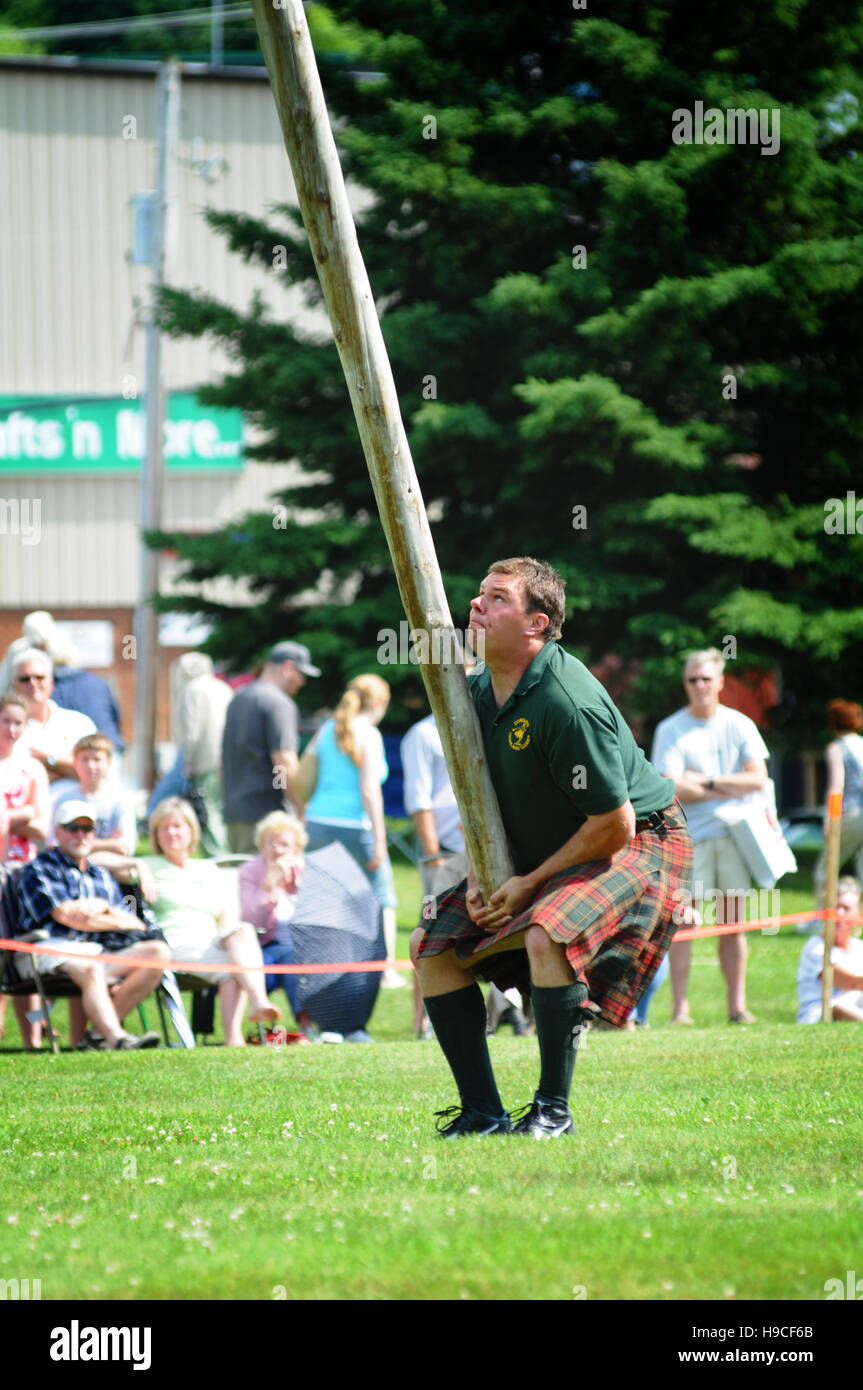 man in a kilt doing the traditional pole toss at the highland games in