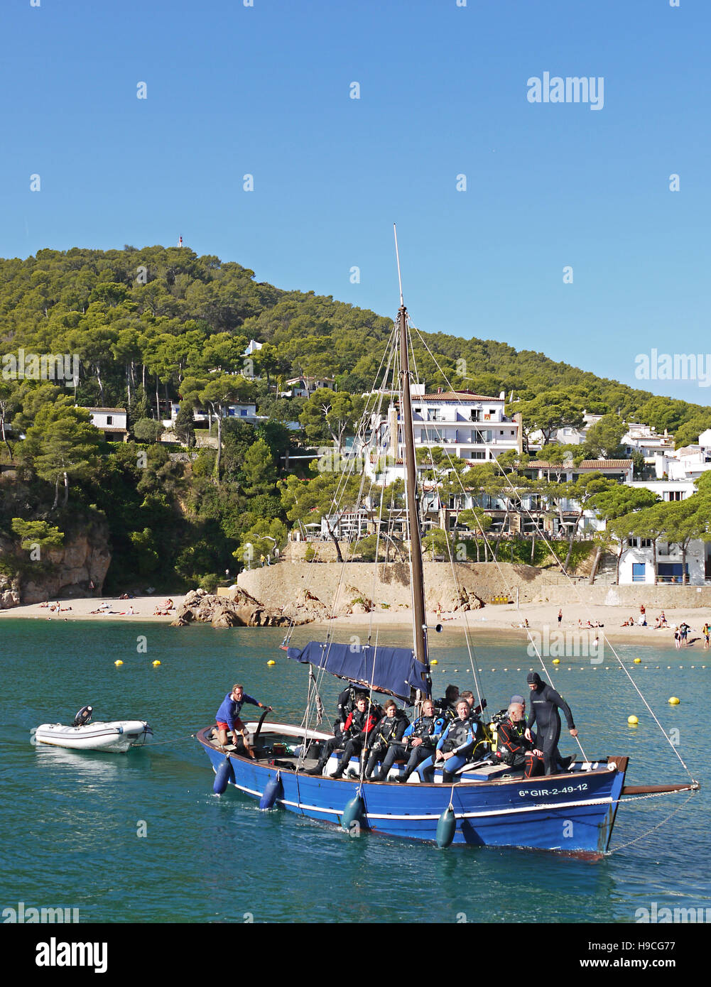 Diving boat heading into the small harbour at Tamariu, Spain, Stock Photo