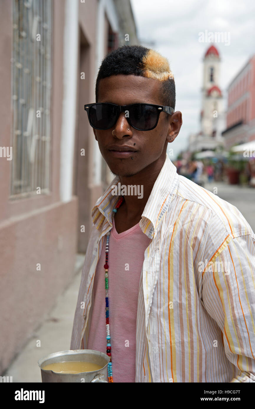 Portrait of a young Cuban man with blonde dyed streak in his hair and lots  of face piercings wearing sun glasses Stock Photo - Alamy