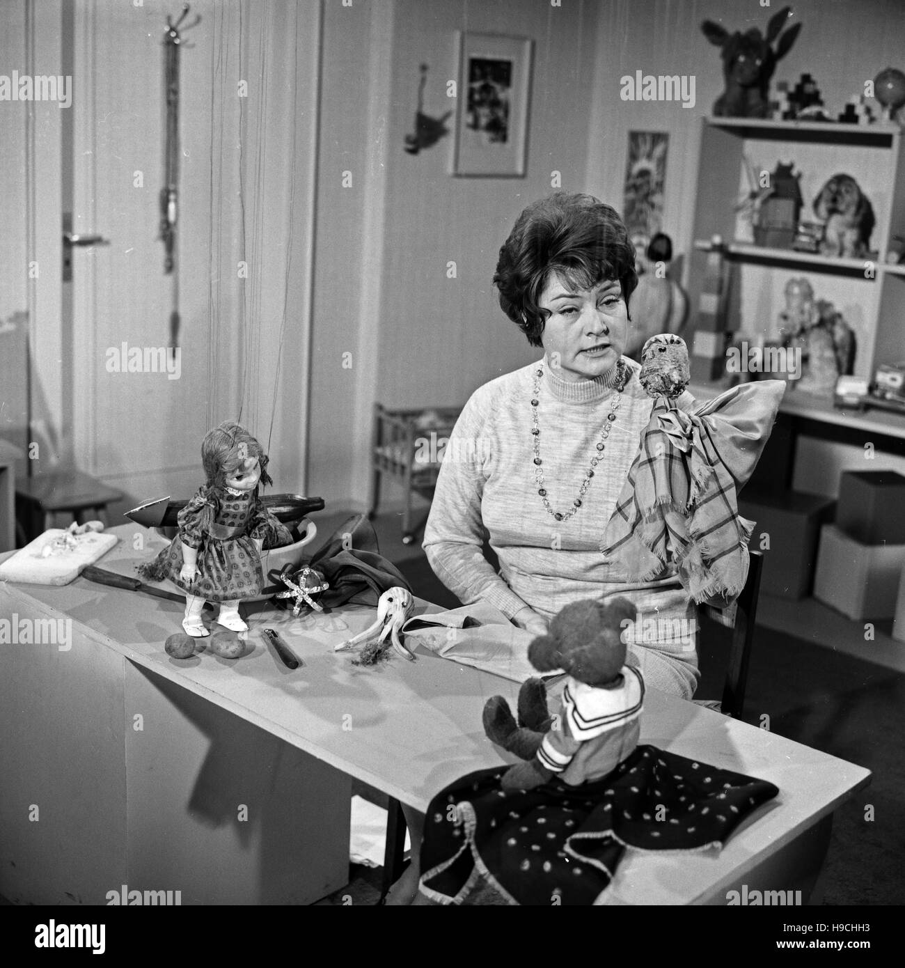 Deutsche Fernsehansagerin und Moderatorin Hilde Nocker erzählt mit den Marionetten Teddy und Puppi eine Sandmännchen Geschichte, Deutschland 1960er Jahre. German TV presenter Hilde Nocker and the puppets Teddy and Puppi present some bedtime stories for children, Germany 1960s. Stock Photo