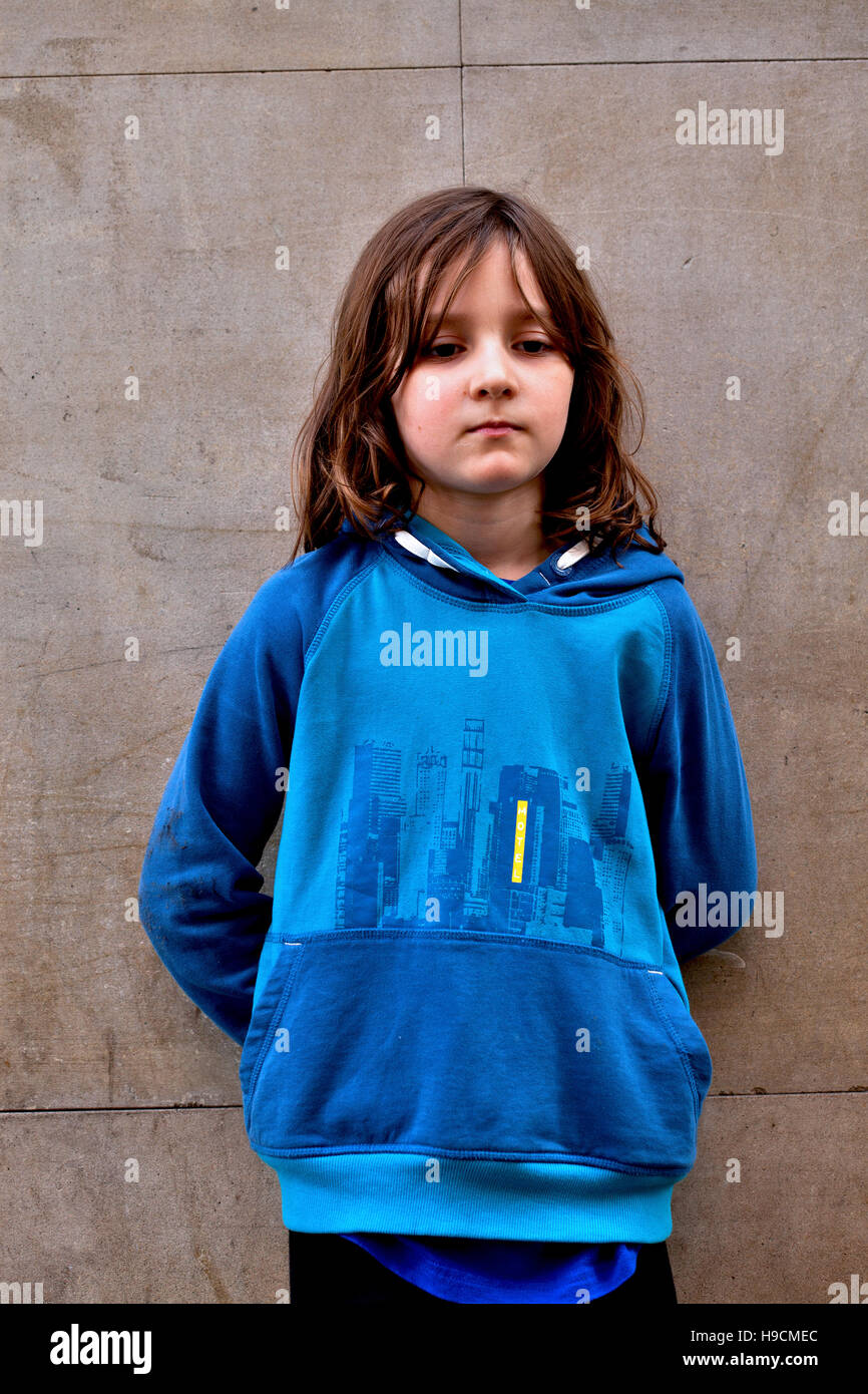 7 year old boy standing quietly by wall. Stock Photo