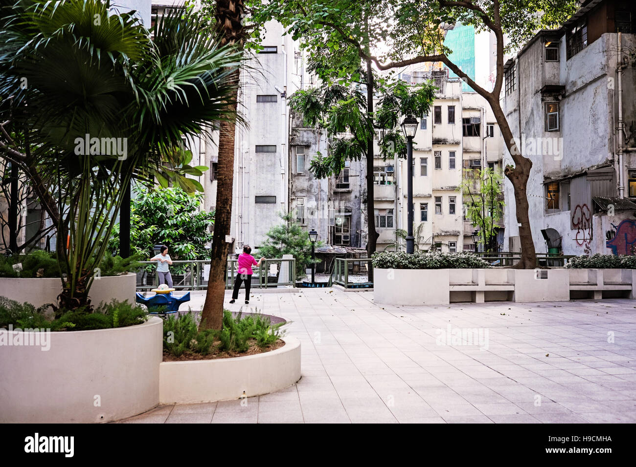 Two women practicing Tai Chi in a court yard in Central, Hong Kong Stock Photo