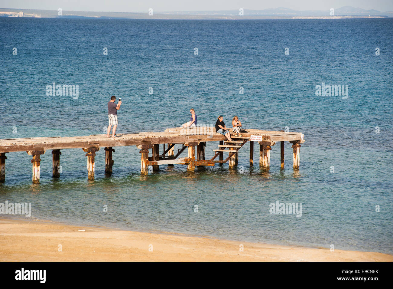 Tourists on a wooden pier in Salamis, Northern Cyprus overlooking the Famagusta bay. Stock Photo