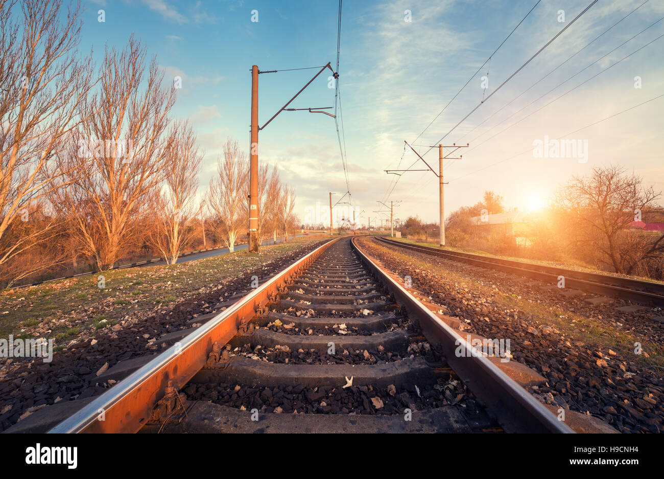 Railway station against beautiful sky at sunset. Industrial landscape with railroad, blue sky. Railway junction Stock Photo