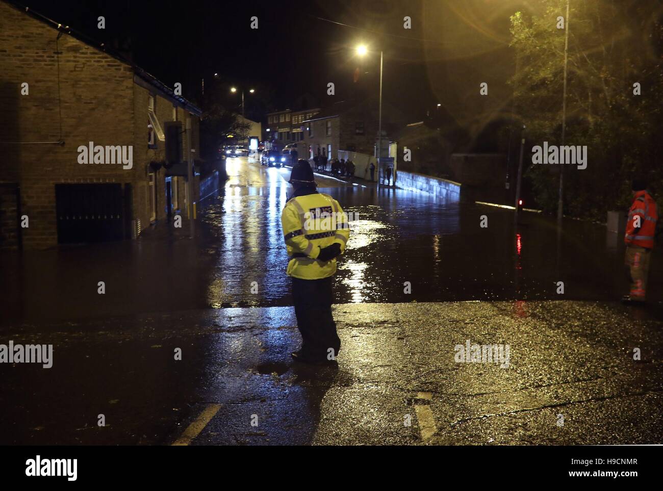 A police officer looks flooding on huddersfield road hires stock