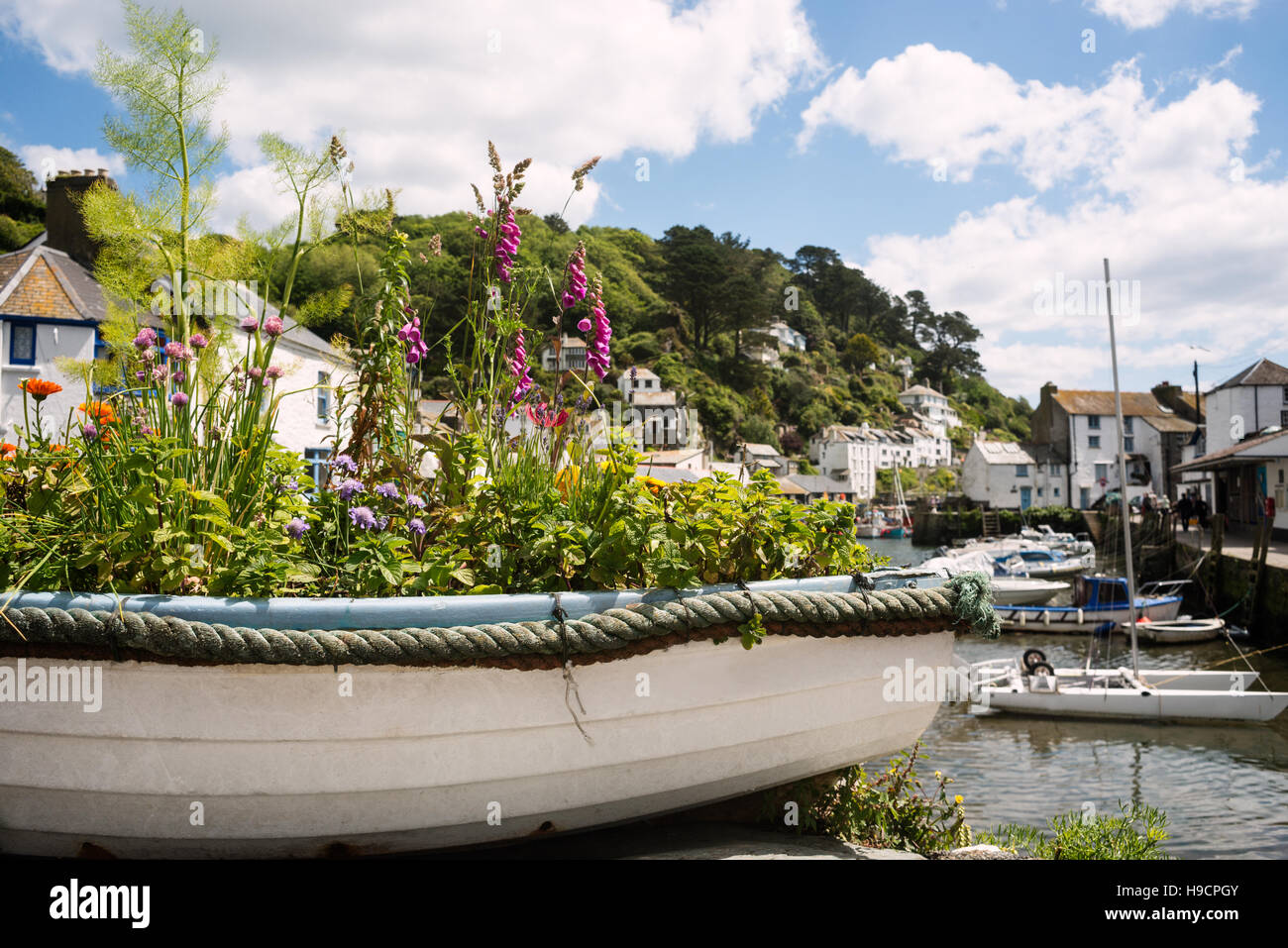 Old boat filled with flowers in summer at resort in Cornwall, UK Stock Photo