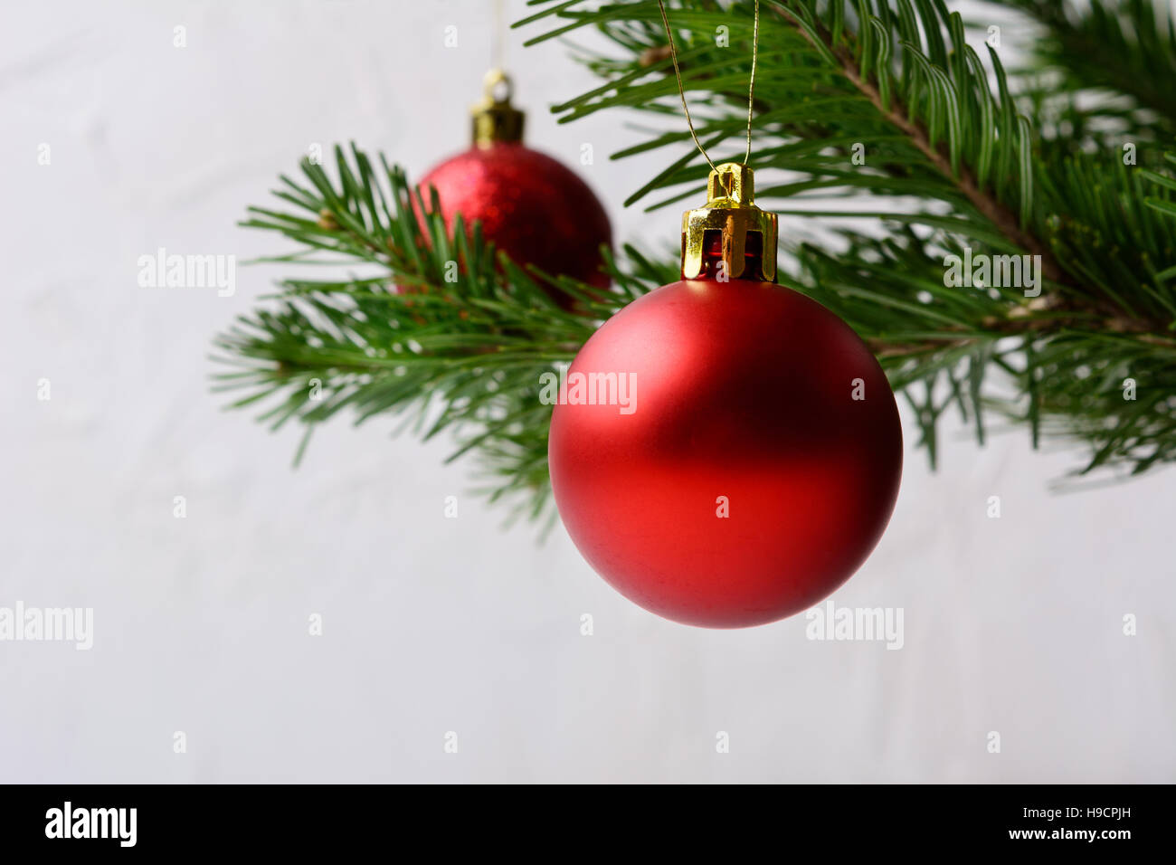 Christmas background with Christmas tree branch and red ornament. Christmas greeting background. Copy space. Stock Photo