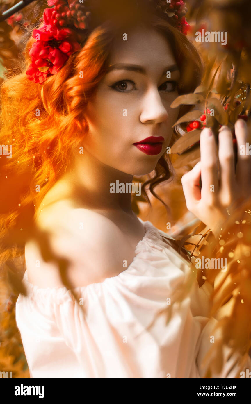 Colorful autumn portrait of beautiful red head model with rowan berries Stock Photo