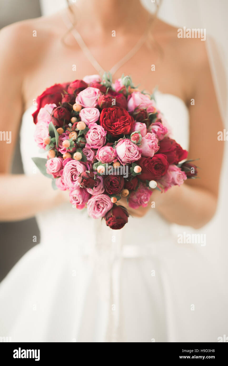 Beautiful bride with wedding bouquet posing in old city Stock Photo - Alamy
