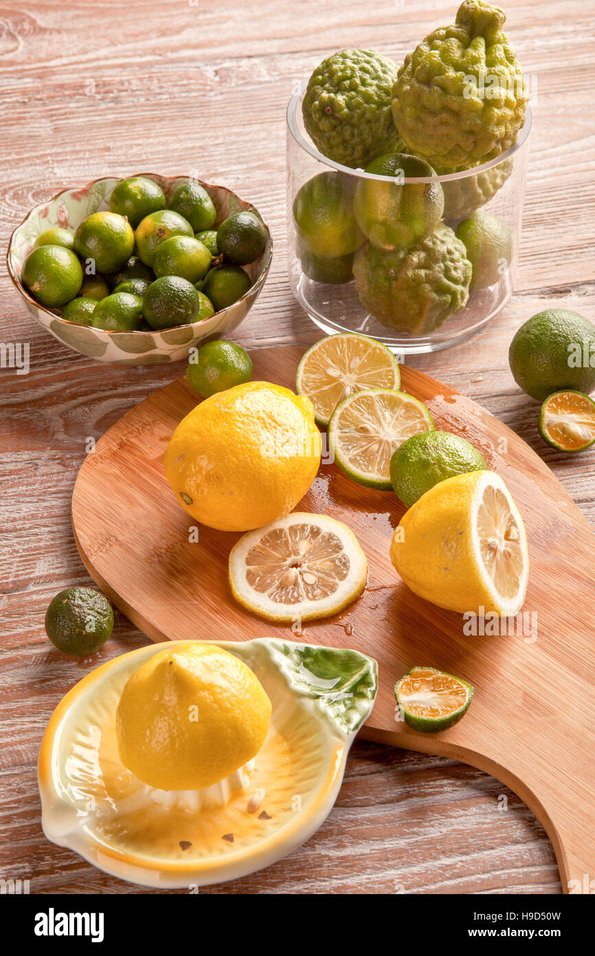 Lime and lemon with squeezer on wooden plank Stock Photo