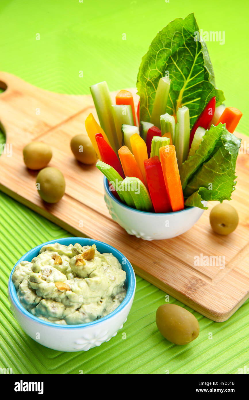Celery and carrot sticks in the glass, olive and yogurt dip Stock Photo
