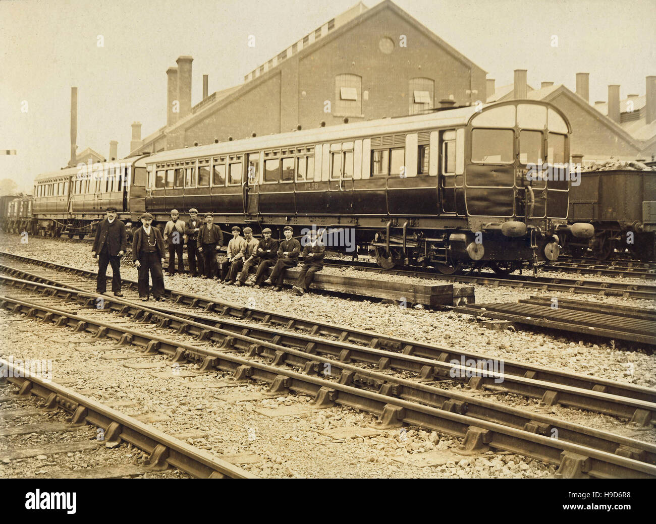 Historic archive image of railway workers pictured in front of railway carriages and sheds somewhere near Carmarthen, Wales. Late 19th or early 20th century. Stock Photo