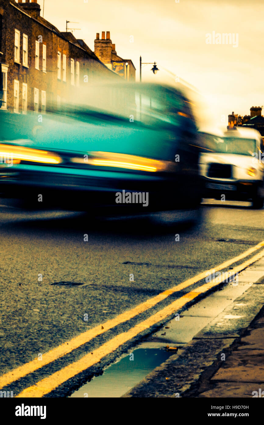 Atmospheric book-cover style low-angle image of motion-blurred cars at night Stock Photo
