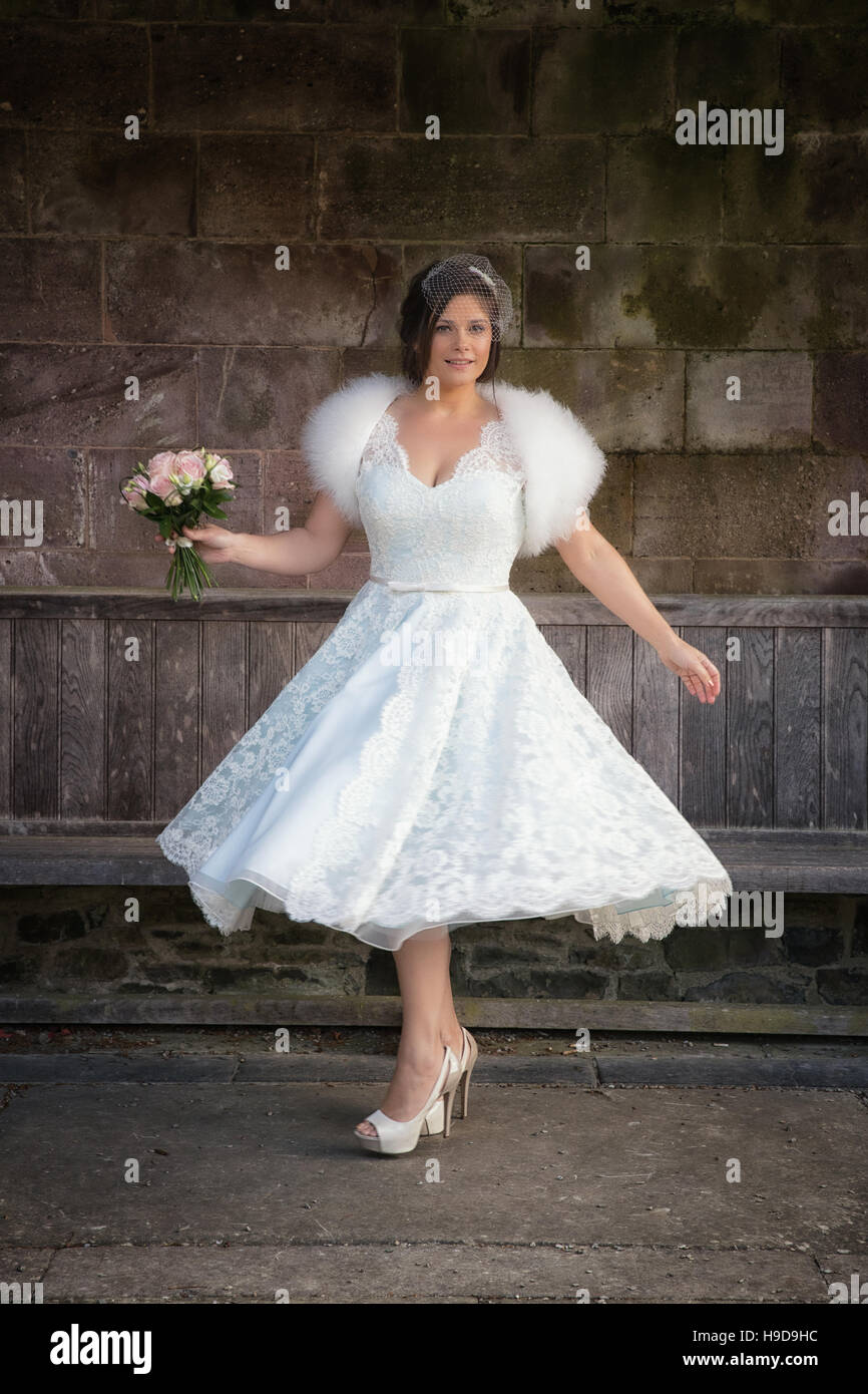 Spinning around in her bridal gown a woman has fun on her wedding day. Stock Photo