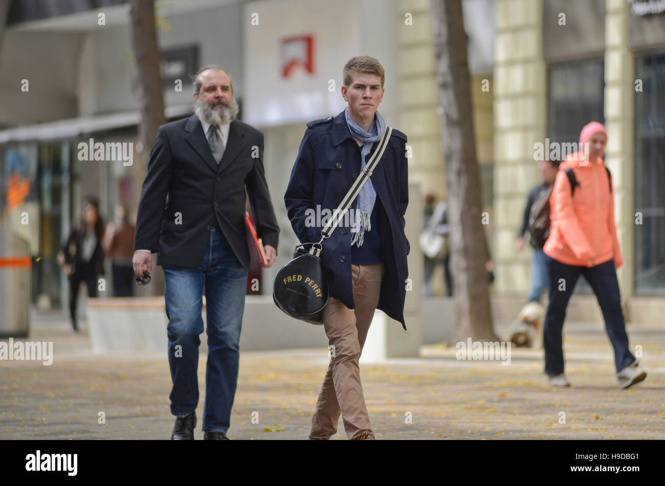 Young and old men walking down the street. Vienna, Austria Stock Photo