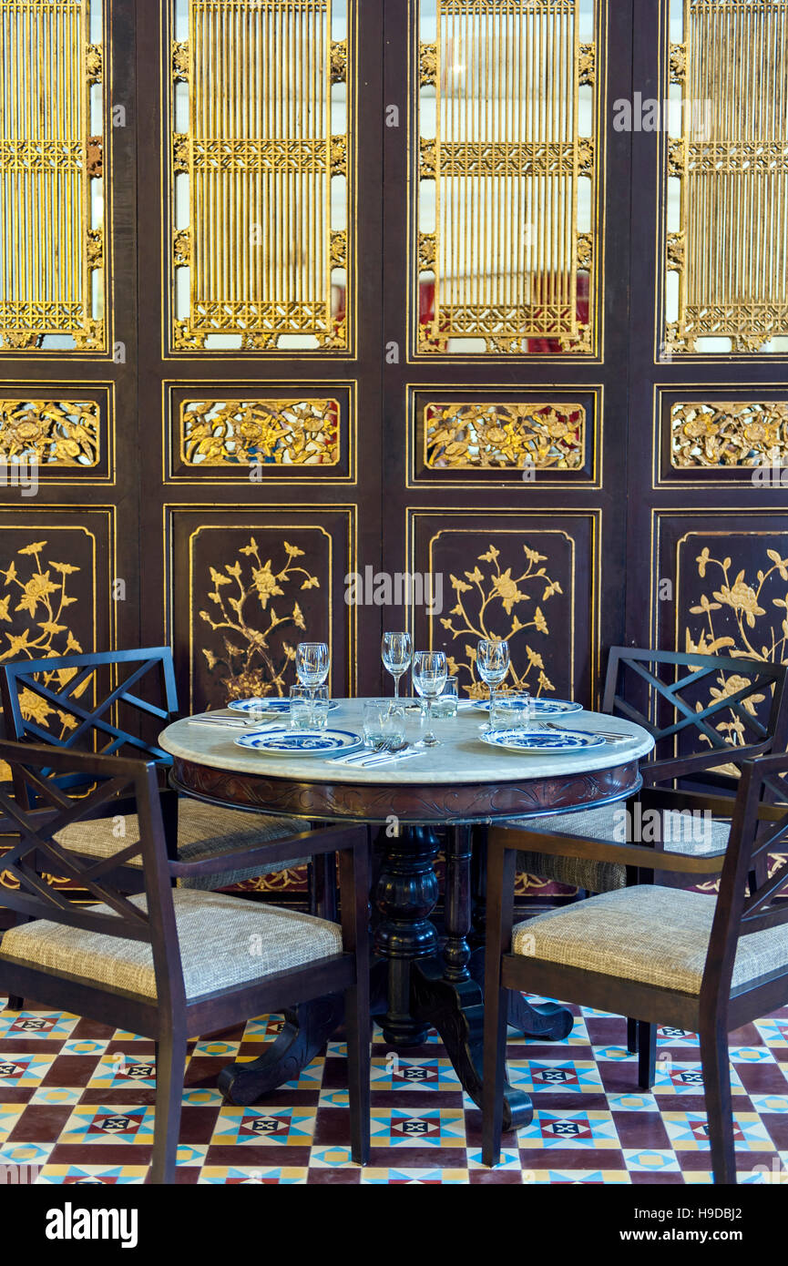 A dining table in front of a Straits Chinese (peranakan) gold leaf