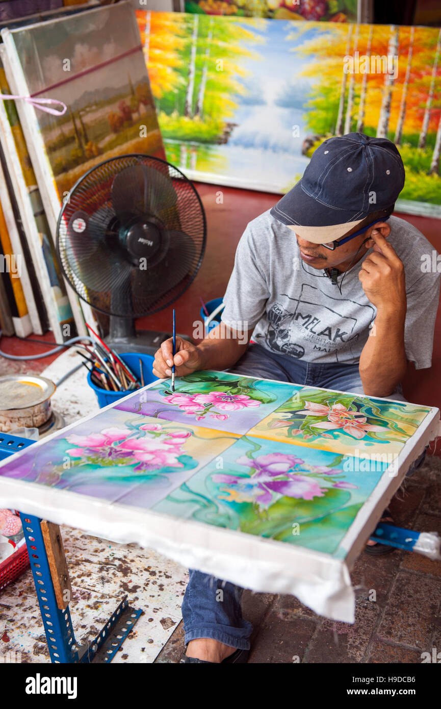 A man painting batik in Malacca, the World Heritage listed town flanking the Straits of Malacca on Peninsula Malaysia. Stock Photo