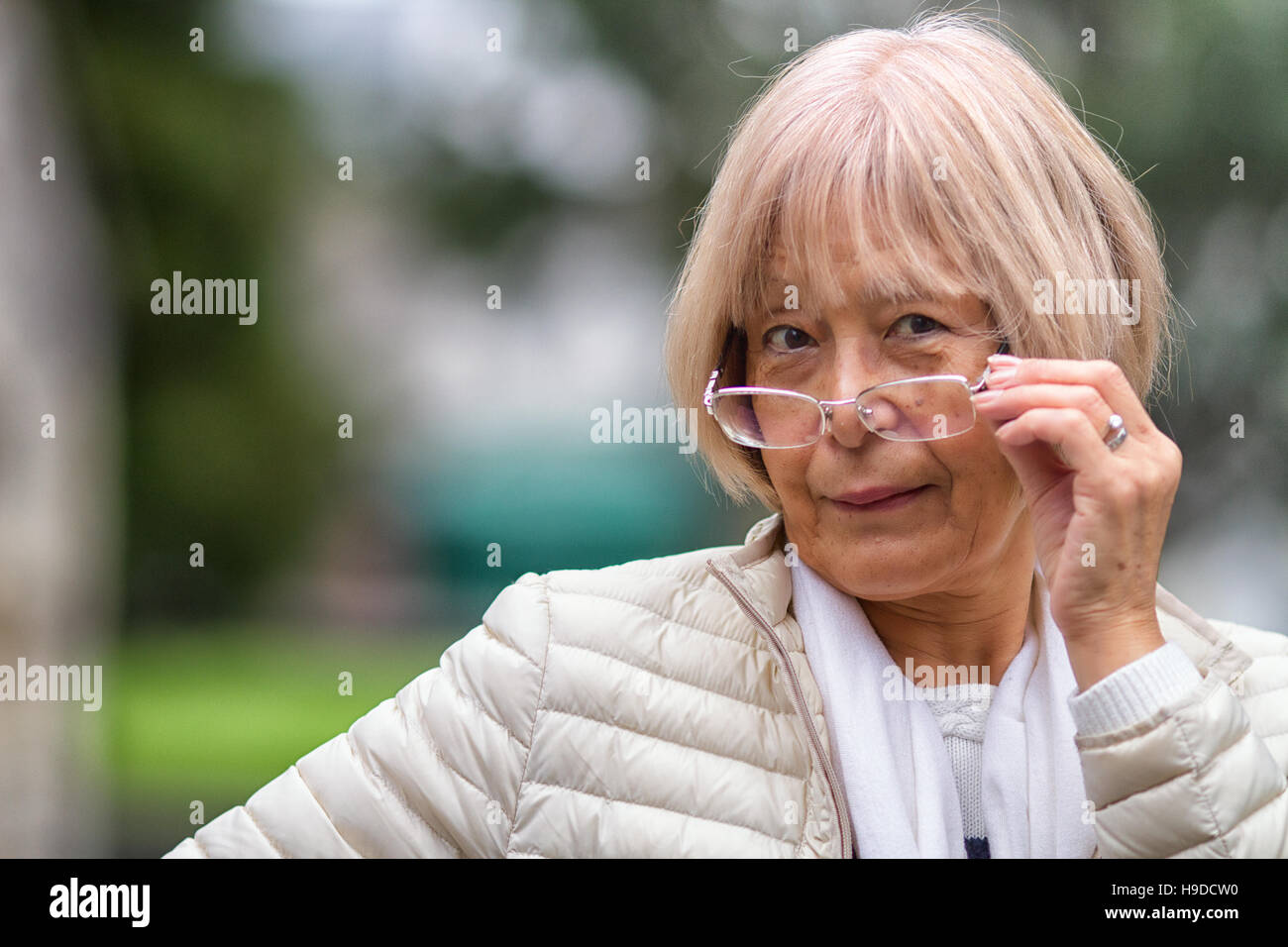 Wise old Japanese lady peers over her glasses at the camera Stock Photo