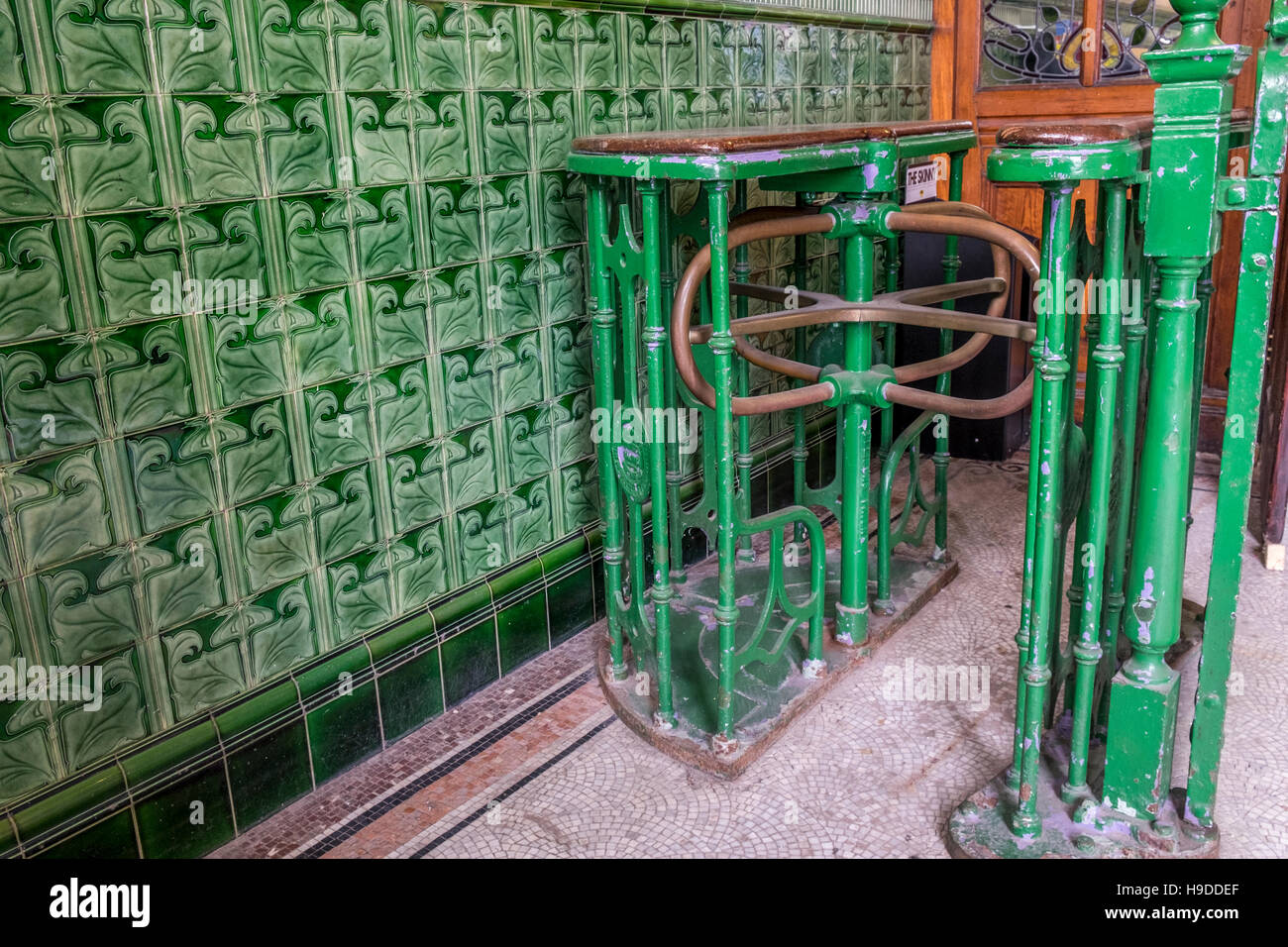 A green old fashioned turnstile allowing people into a building Stock