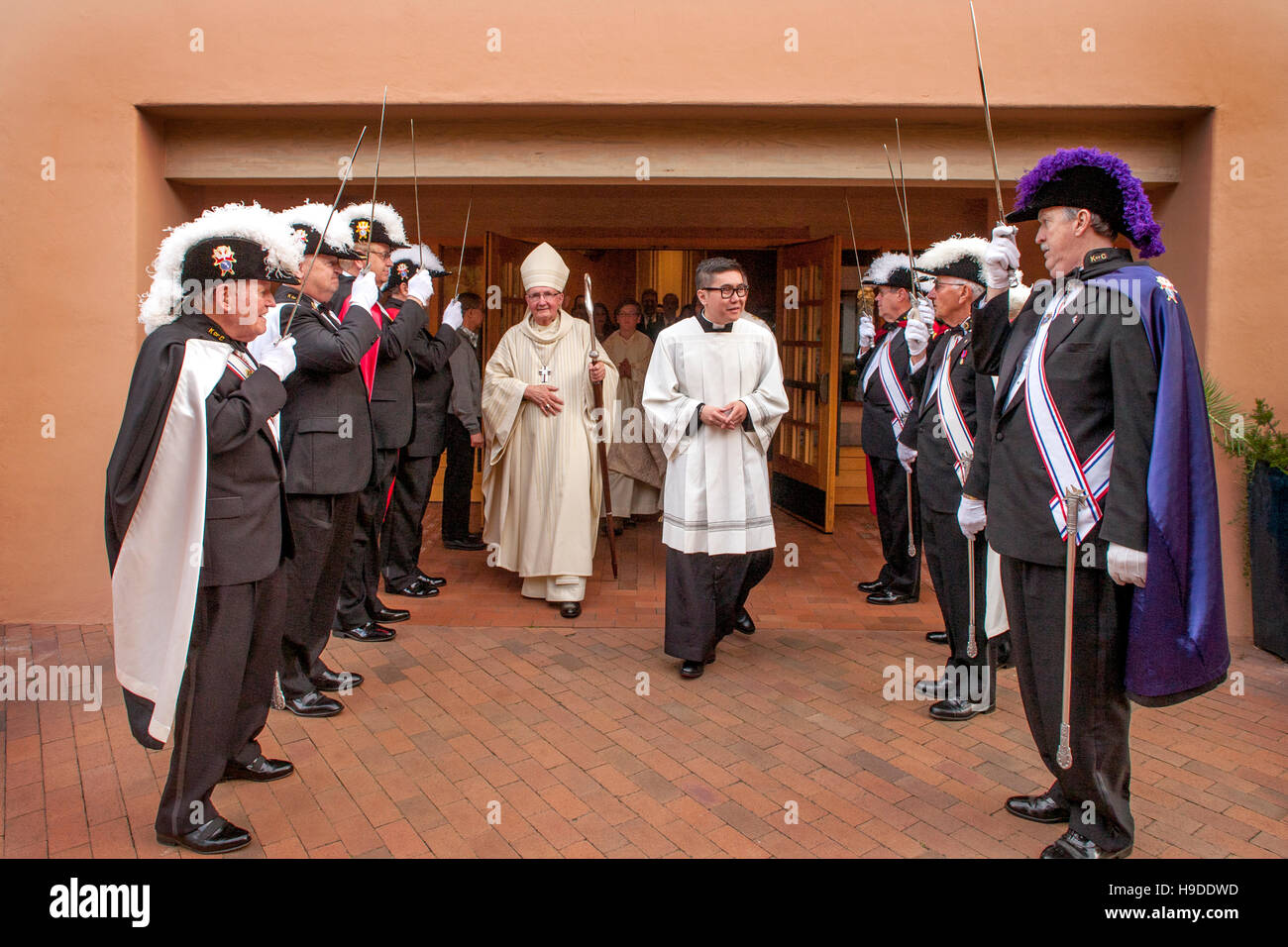 A visiting bishop is greeted by elaborately costumed members of the Knights of Columbus at St. Timothy's Catholic Church, Laguna Niguel, CA. Note ceremonial swords and priest at right center. Stock Photo