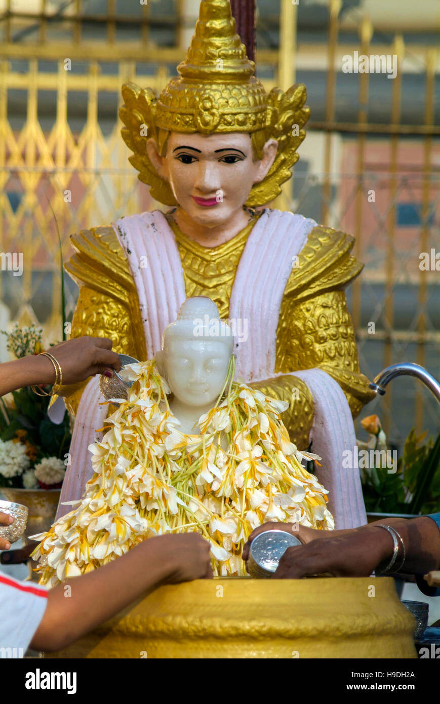 Devotees making offerings to a Buddha statue at the Shwedagon Pagoda in
