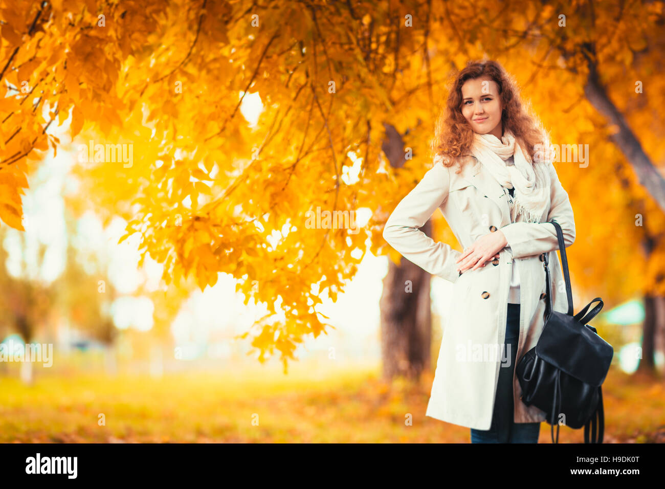 young girl in a light coat on the background of autumn park Stock Photo ...