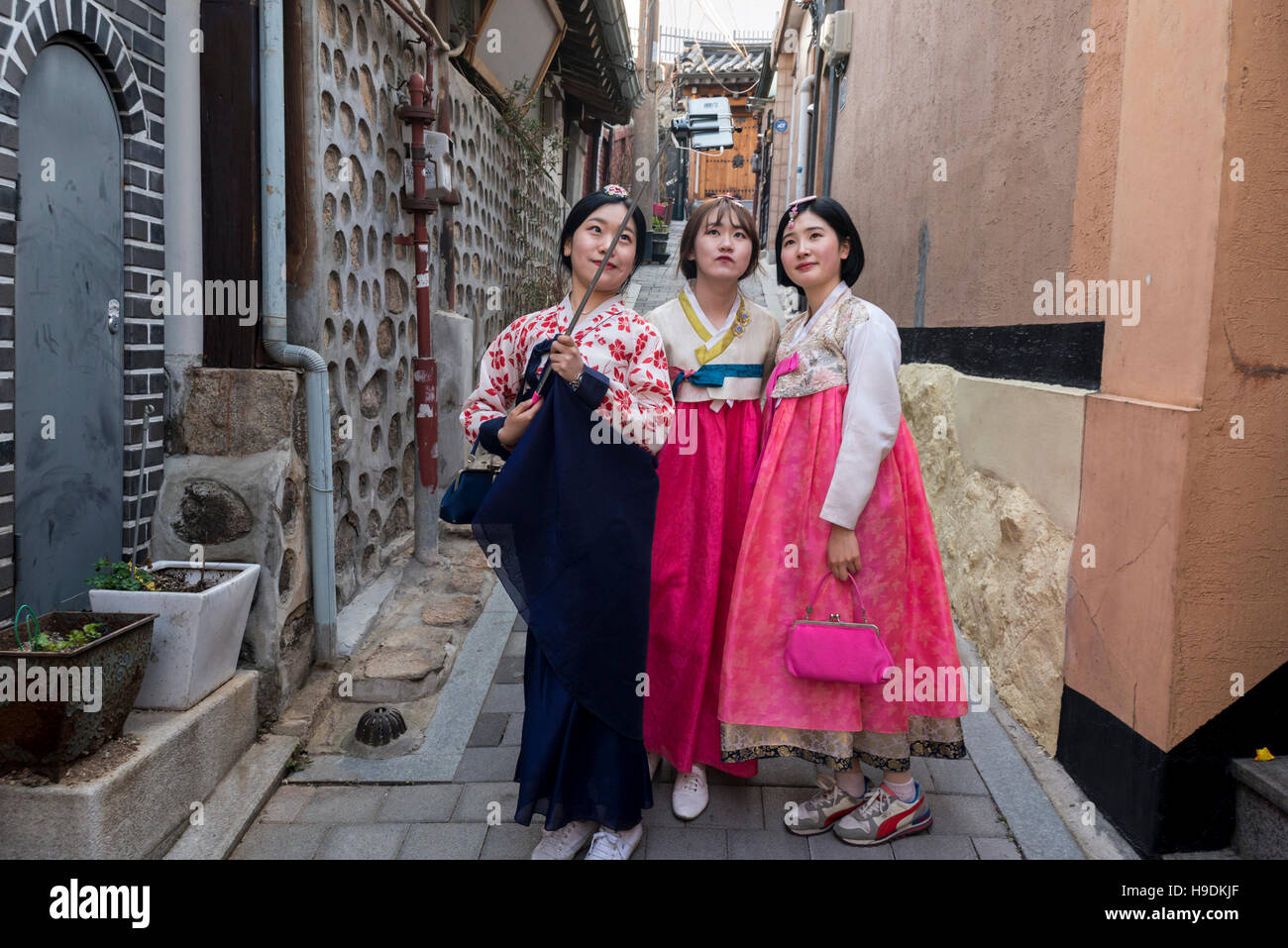 3 young female wearing traditional Korean costume taking selfies, Bukchon Hanok Village, Seoul, Korea Stock Photo
