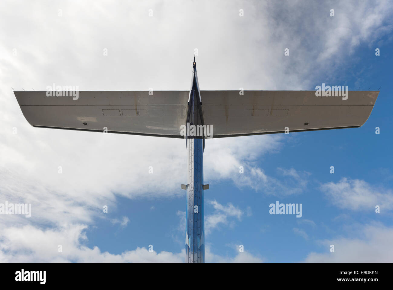 Airplane wing tale viewed from below with blue sky. Horizontal Stock Photo