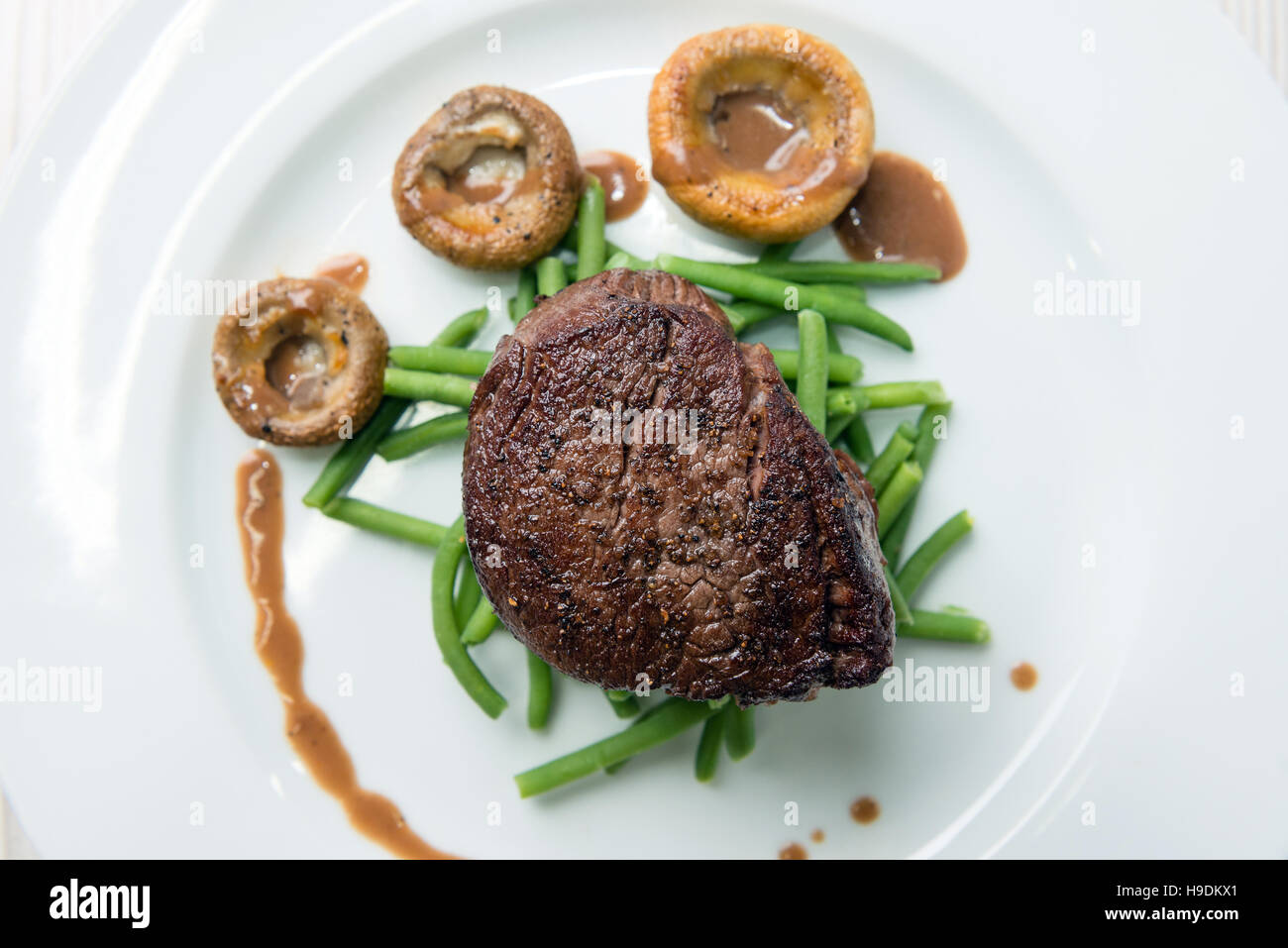 Delicious sirloin steak with green beans and mushrooms Stock Photo - Alamy