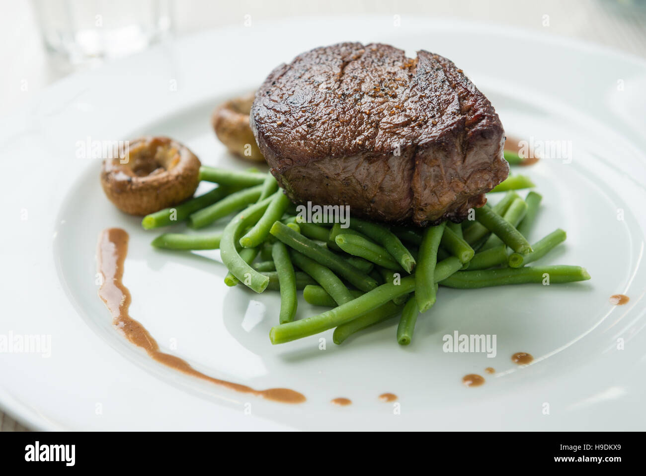 Delicious sirloin steak with green beans and mushrooms Stock Photo - Alamy