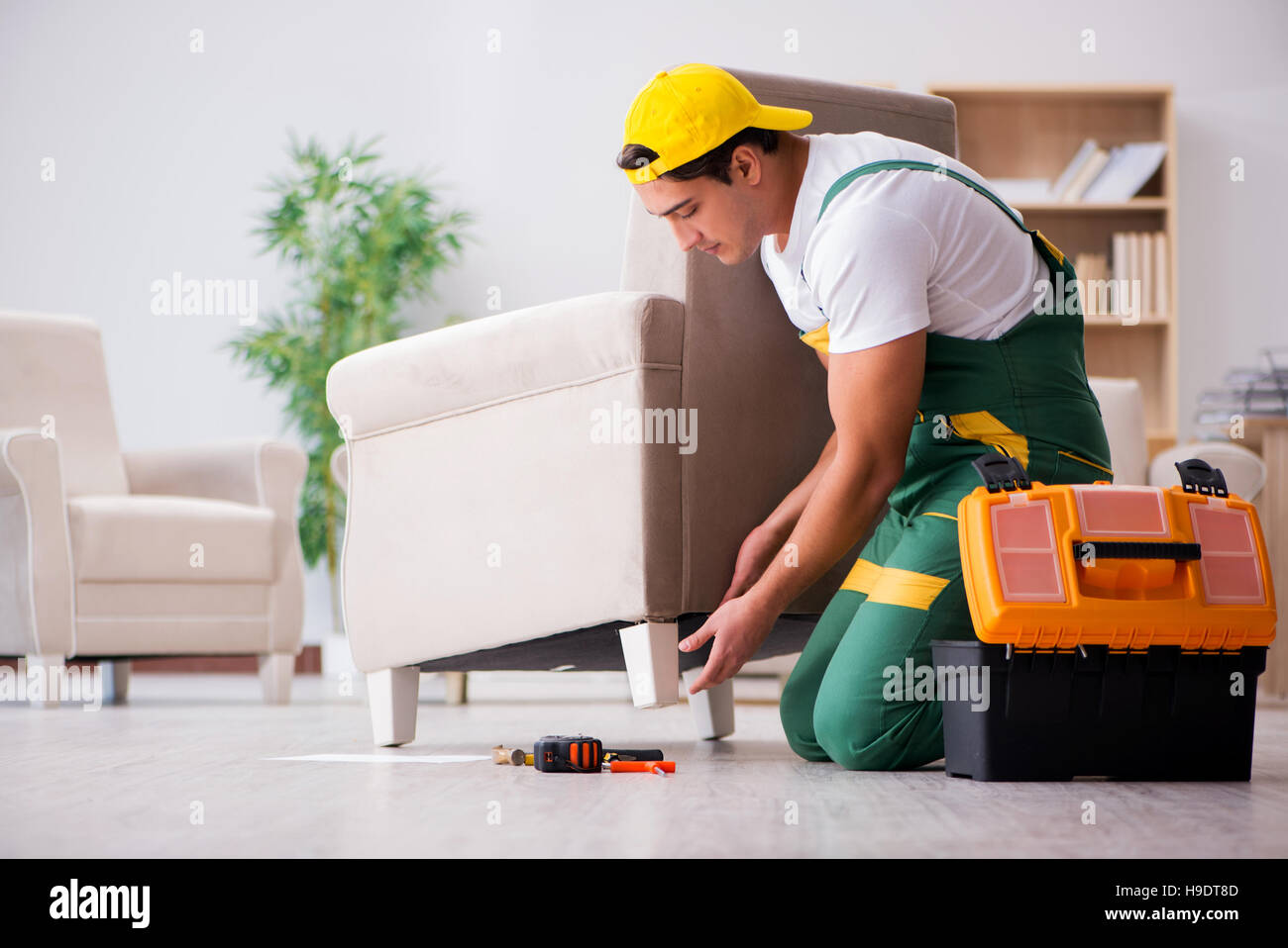 Furniture repairman repairing armchair at home Stock Photo Alamy