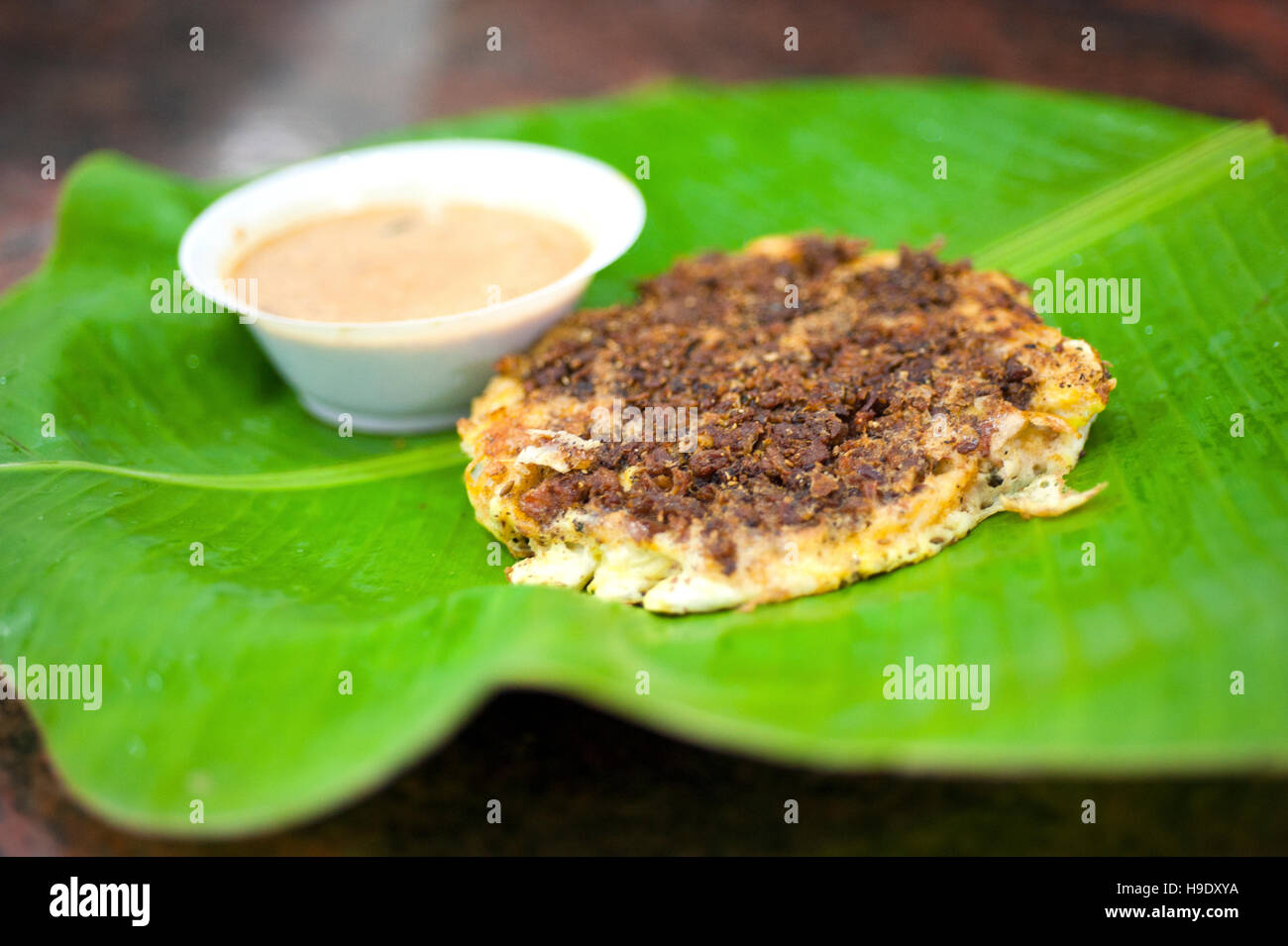 Mutton kari dosa, or Madurai dosa, made of fermented rice and lentils and topped with a mutton curry, at Simmakkal Konar Kadai in Madurai, India. Stock Photo