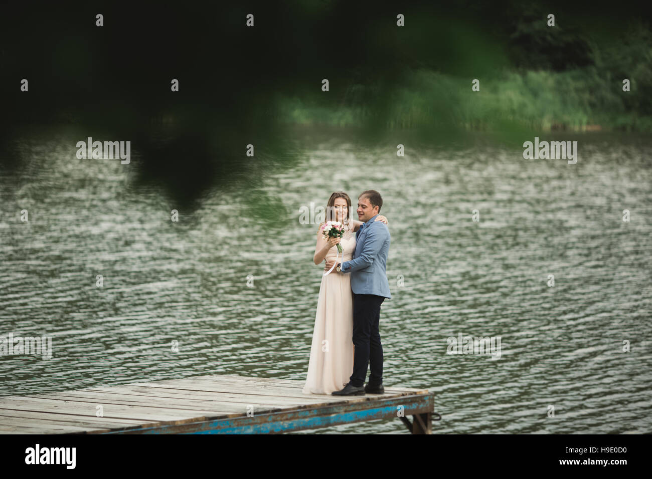 Bride and groom walking on the river, smiling, kissing Stock Photo - Alamy