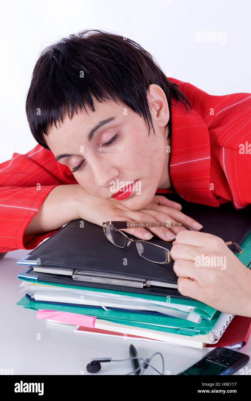 Exhausted businesswoman sleeping on a pile of files in the office Stock ...
