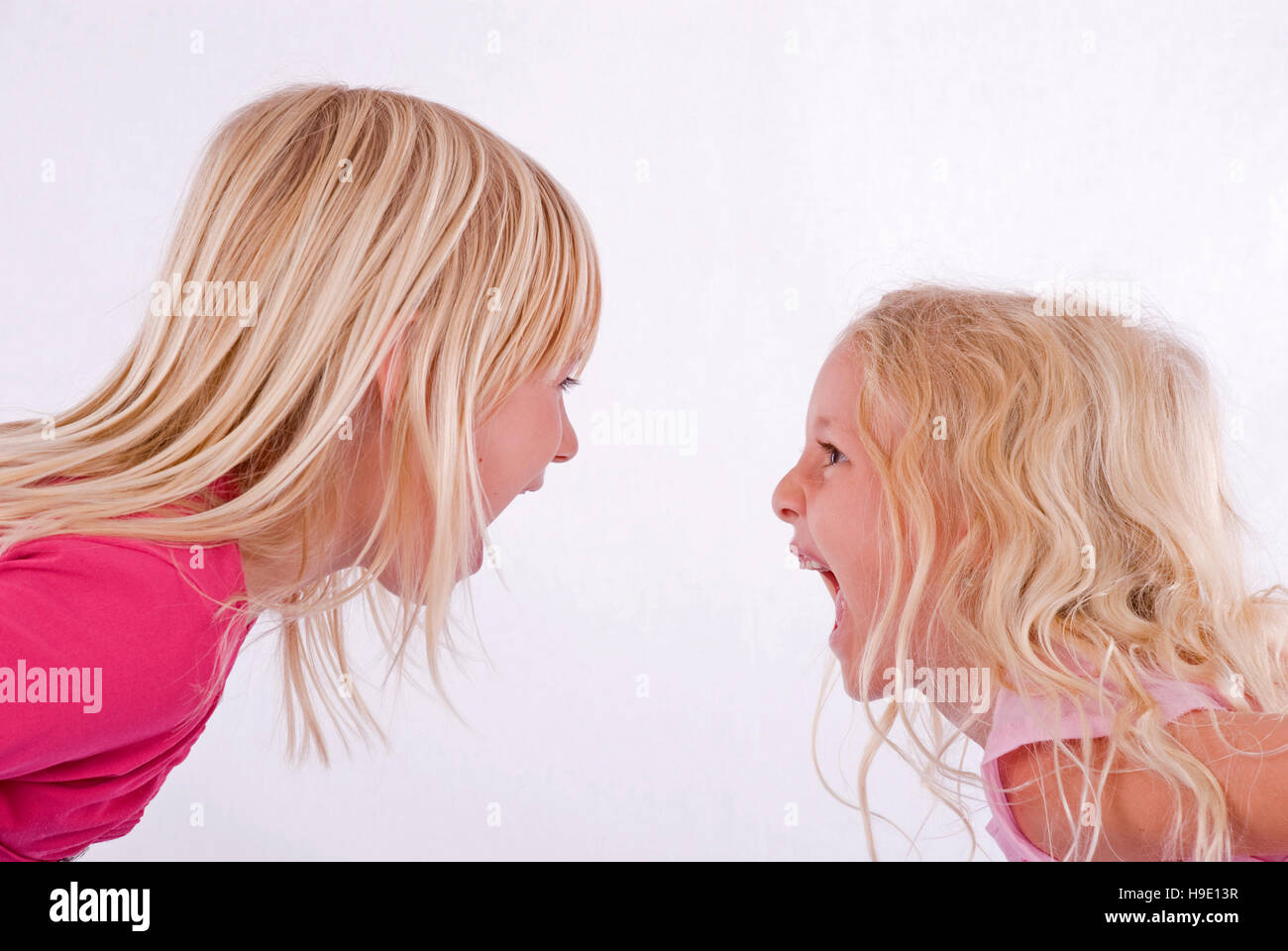 Two blonde girls screaming at each other Stock Photo