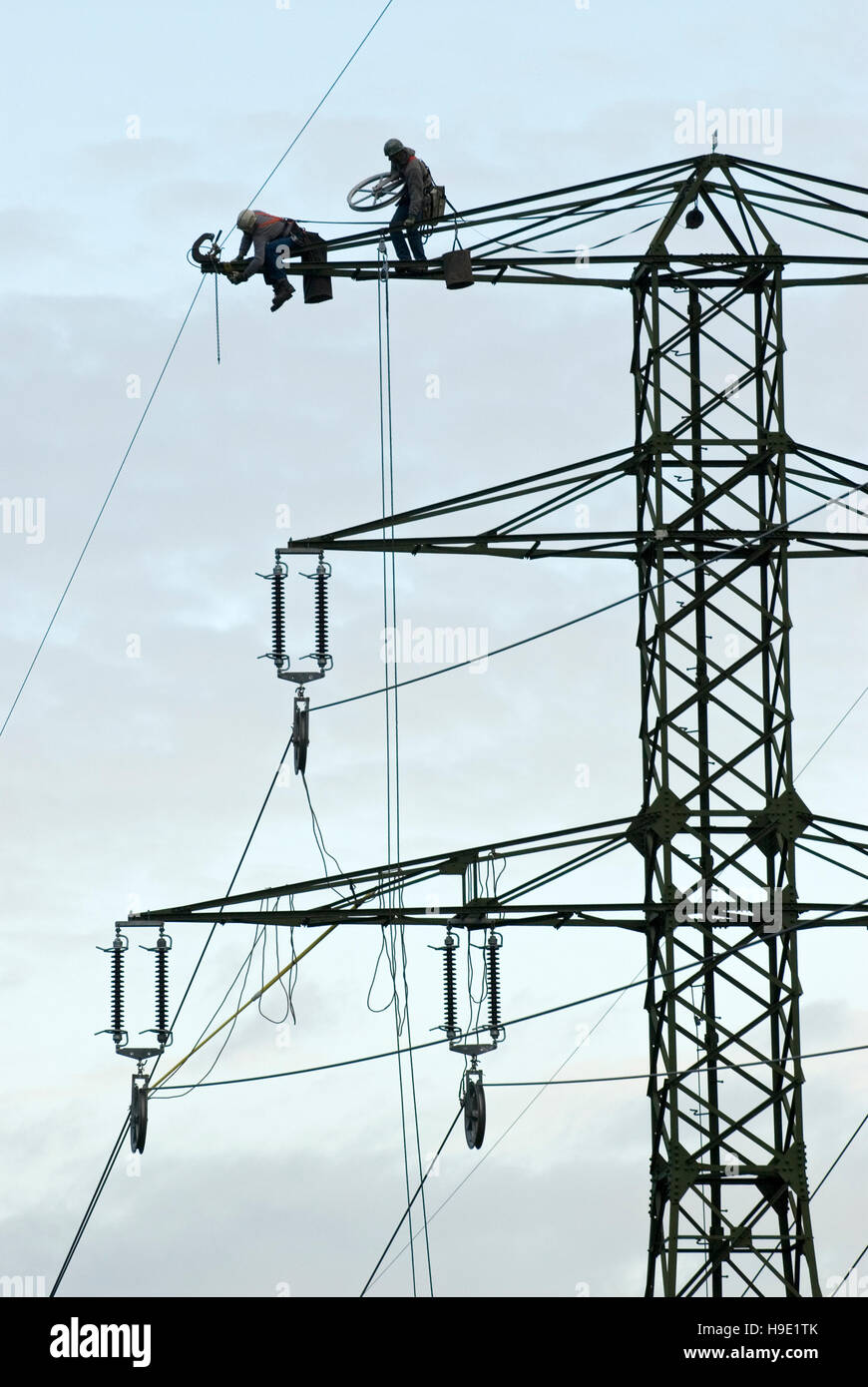 Two men working on an electric pylon Stock Photo