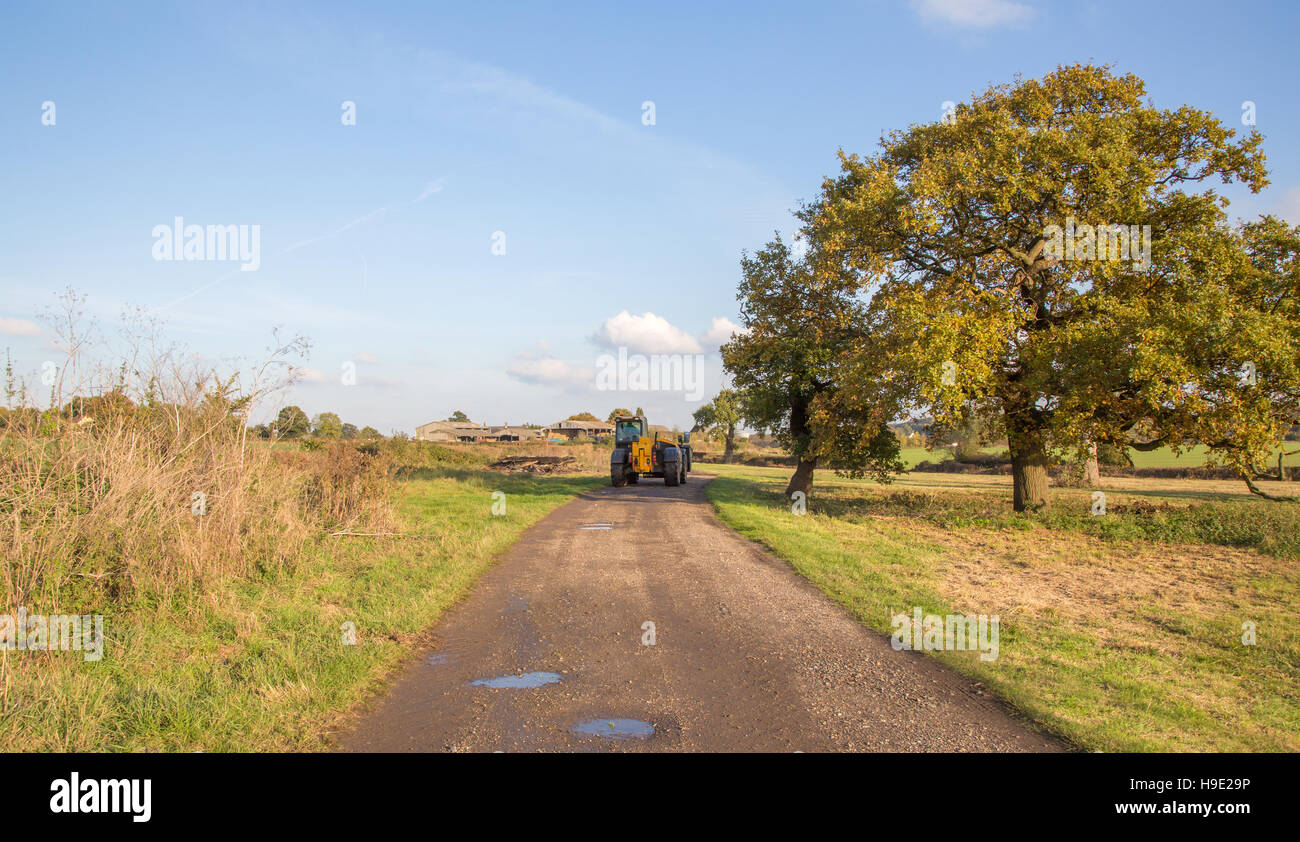 Tractor on a country path in the autumn countryside on a sunny November afternoon. Stock Photo