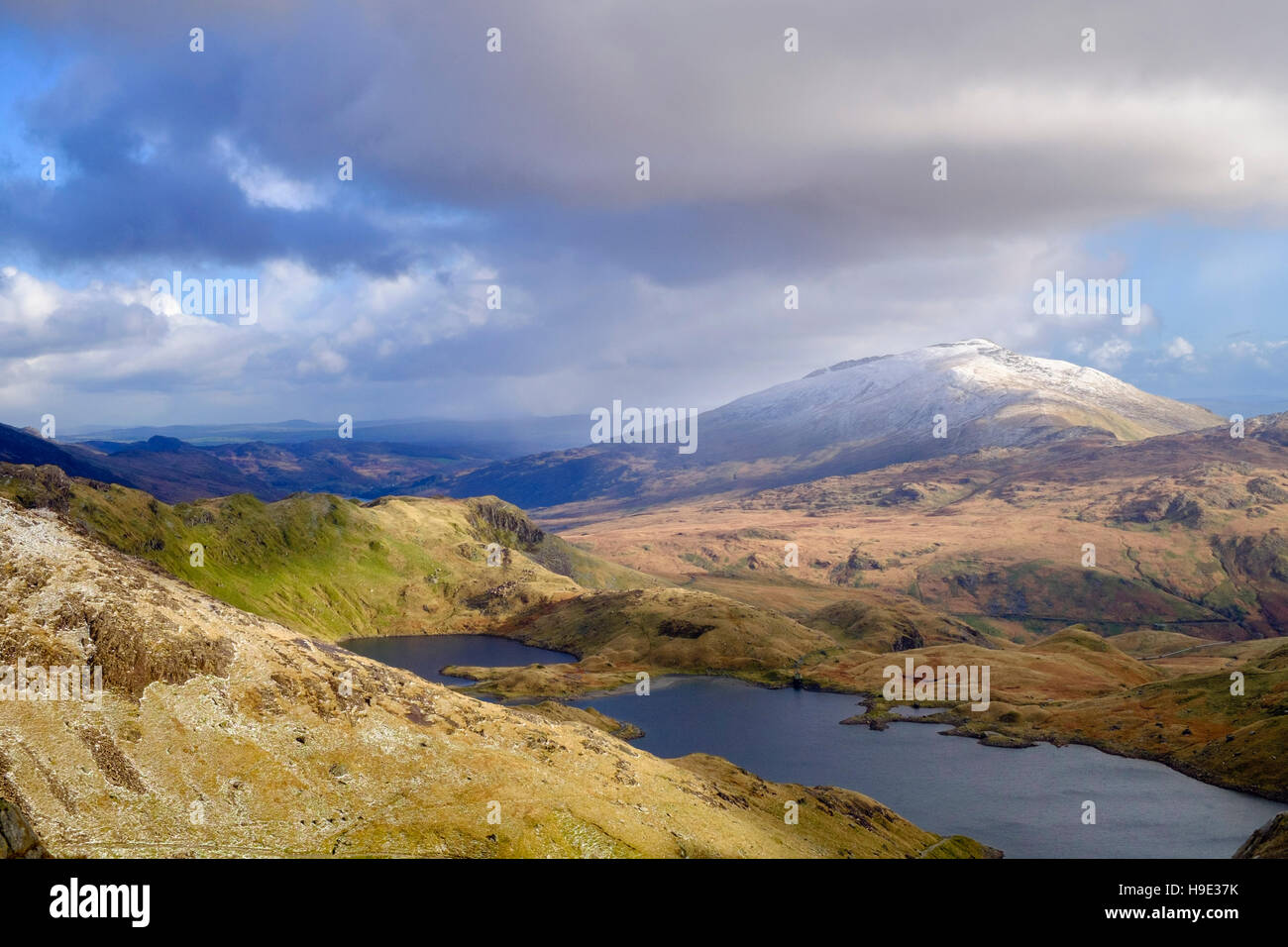 View to Llyn Llydaw lake and distant Moel Siabod from Y Gribbin ridge in Snowdon horseshoe with snow in winter.  Snowdonia National Park Wales UK Stock Photo