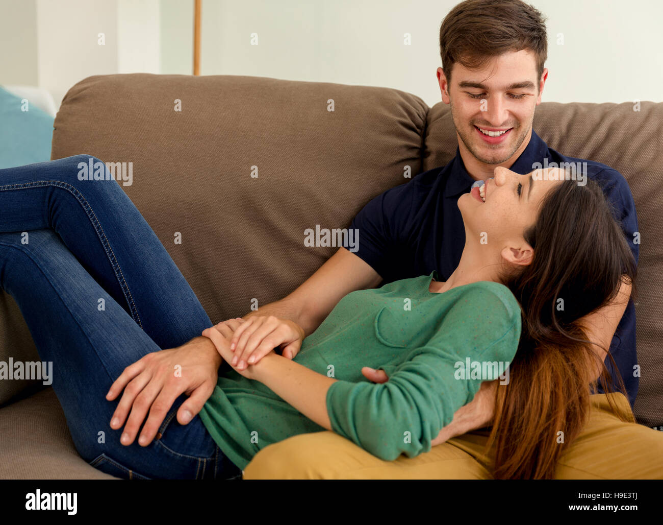 Young couple sitting on the sofa and dating Stock Photo