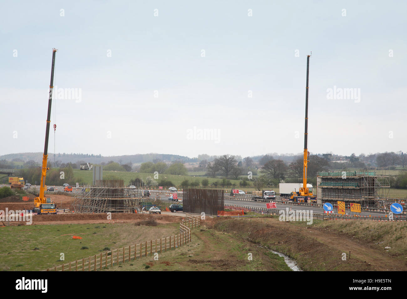 Construction of a new bridge for the A46 to span the M40 motorway, Oxfordshire, UK. Shows formwork for bridge piers and 2 cranes Stock Photo