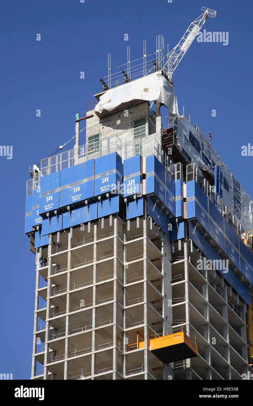 Protective climbing screens surround the top of a new, concrete framed tower block as it is constructed in Central London, UK Stock Photo