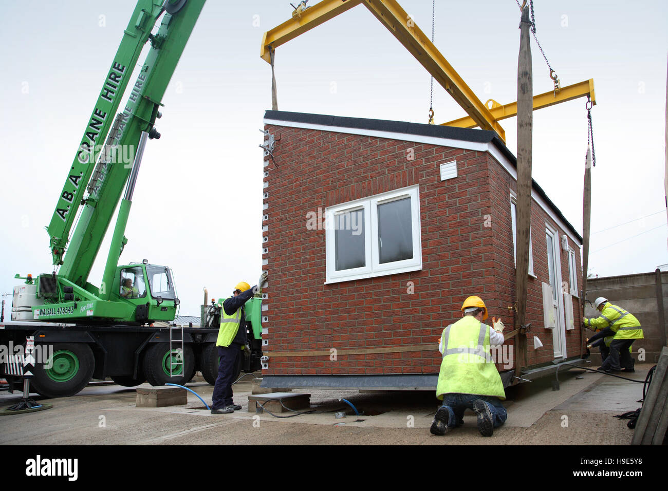 Prefabricated, full-fitted kitchen modules are craned into place on a travelers caravan site in Pathlow, Warwickshire, UK Stock Photo